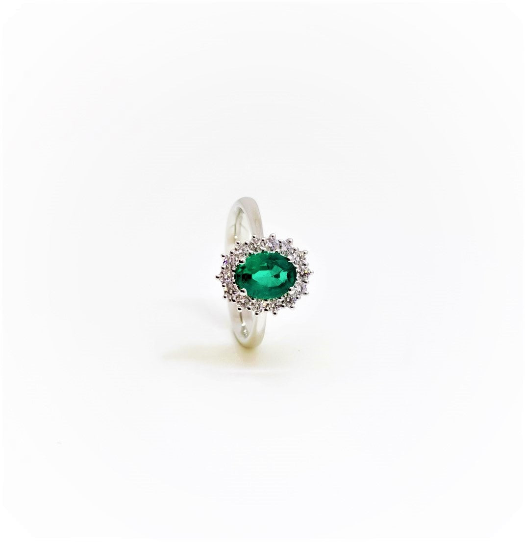 Anillo en oro blanco con halo de diamantes y esmeralda corte ovalada