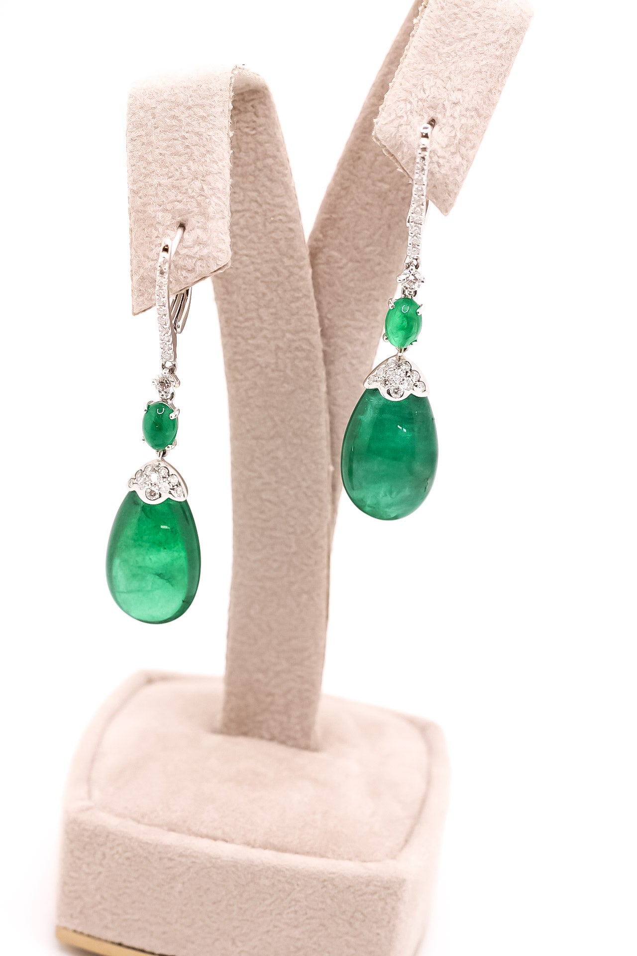 Aretes semi largos en oro blanco con cabujón de esmeralda en forma de pera y diamantes